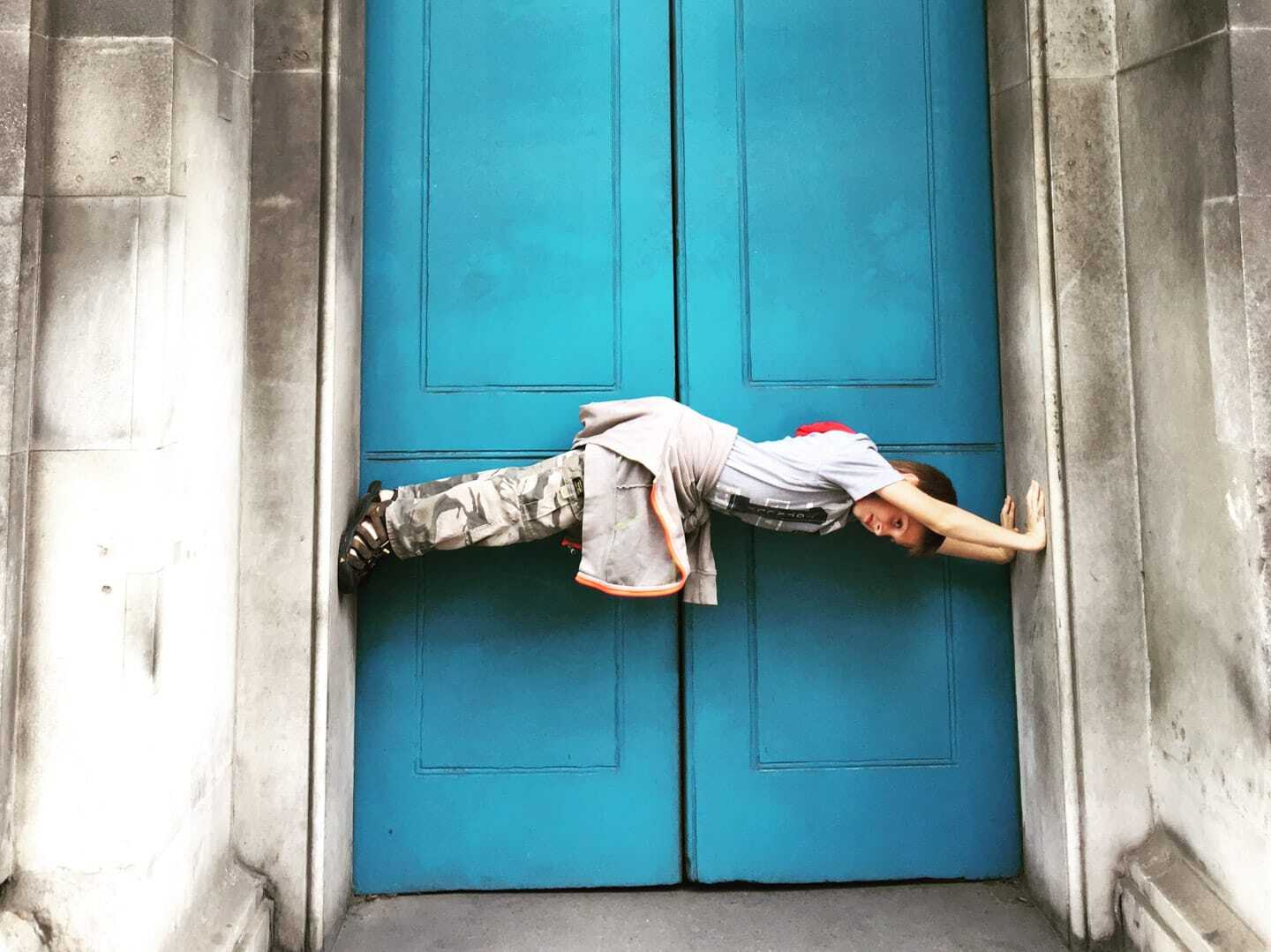 Boy balancing between doorway